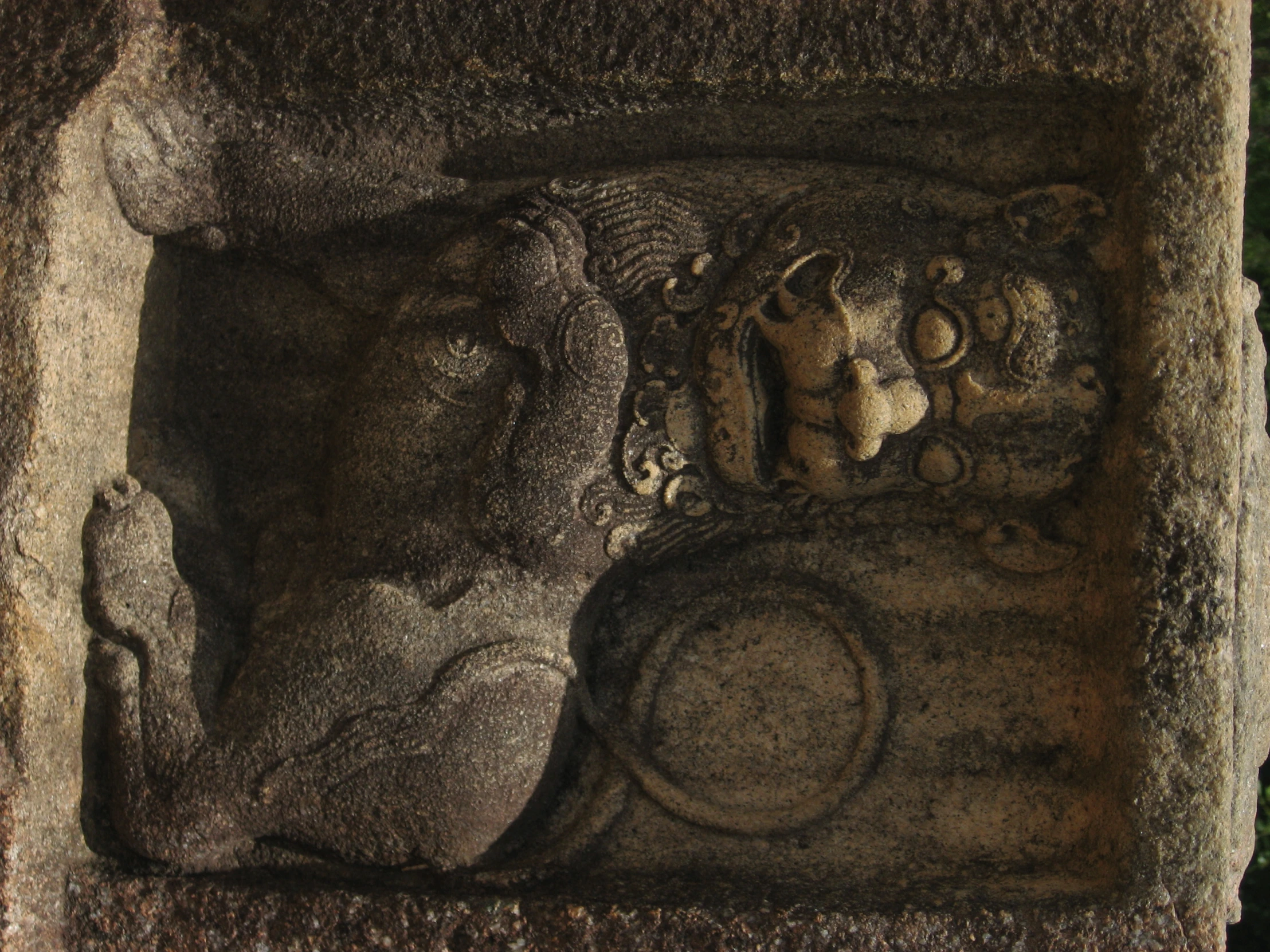 a statue of a bull with a circular figure next to it