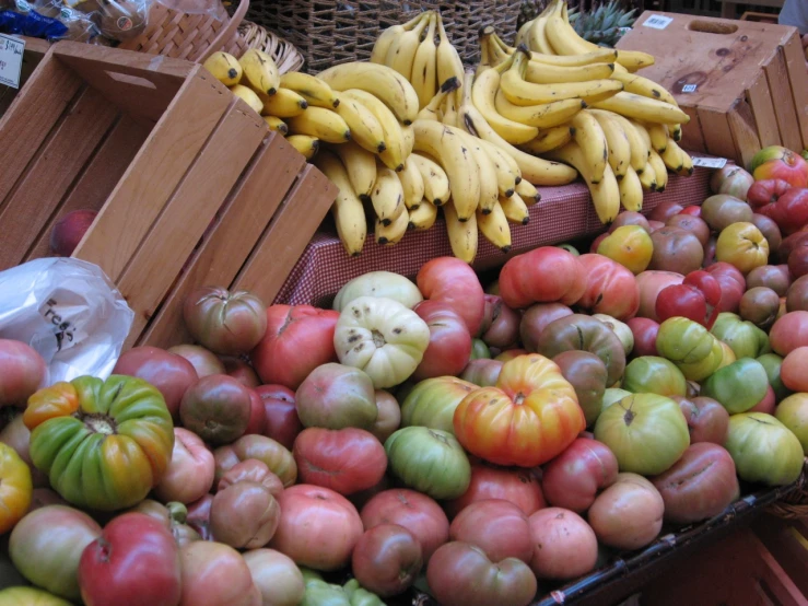 apples, tomatoes, and bananas are piled up