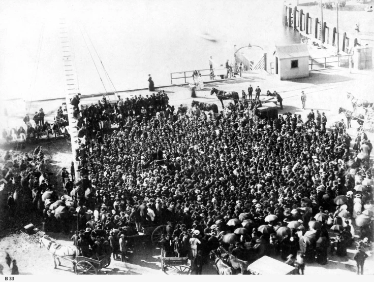 an old pograph of many men standing in front of a large boat