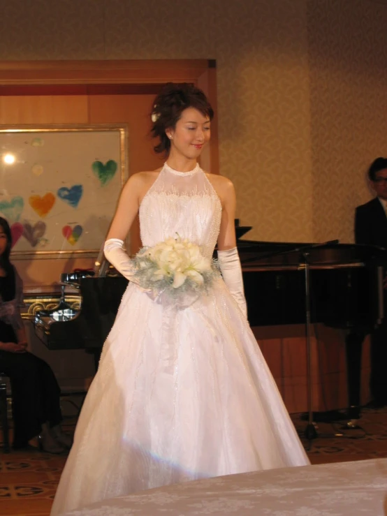 a bride in a wedding dress is on the stage at a musical performance