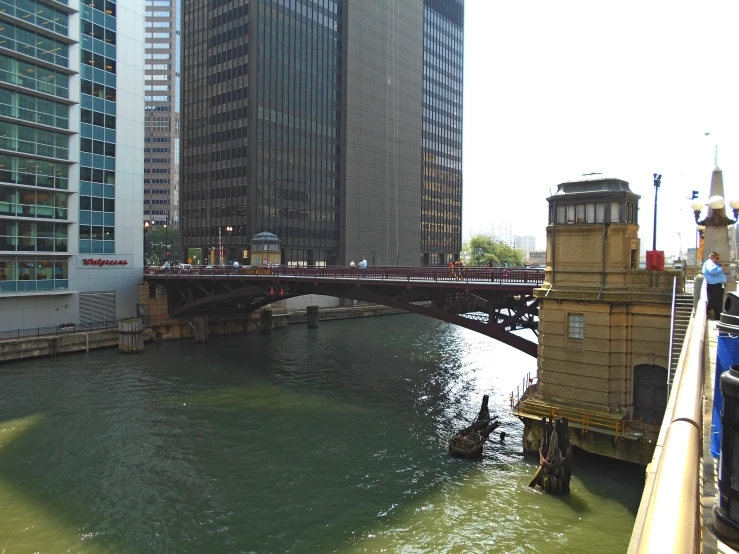 people ride on a boat on a river in front of large buildings