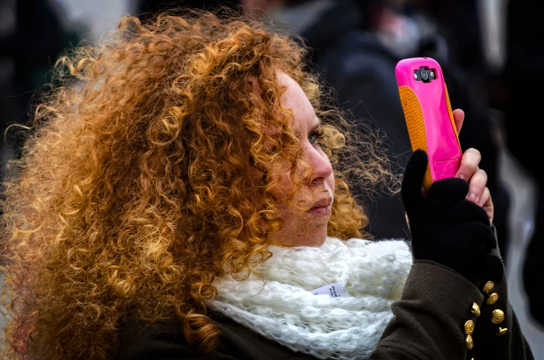 a woman holding a phone and looking at the screen