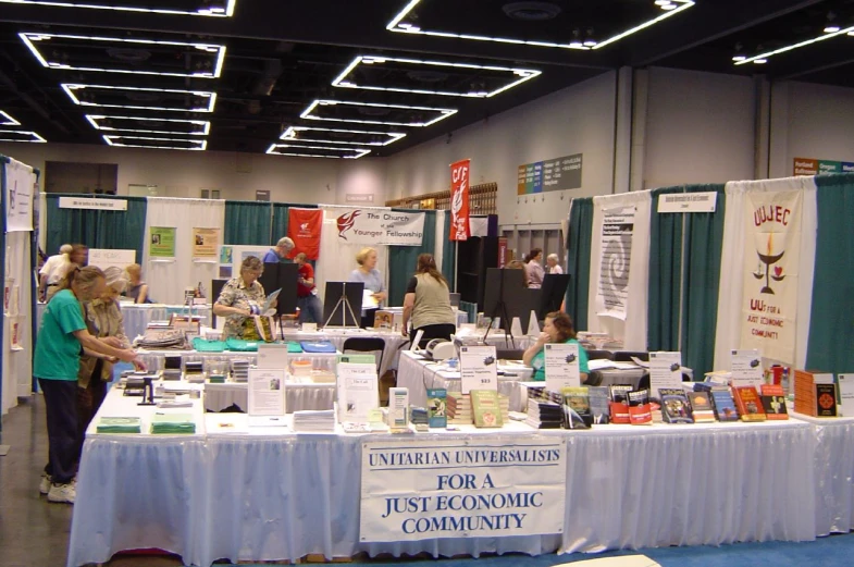 tables in a convention area with people buying items