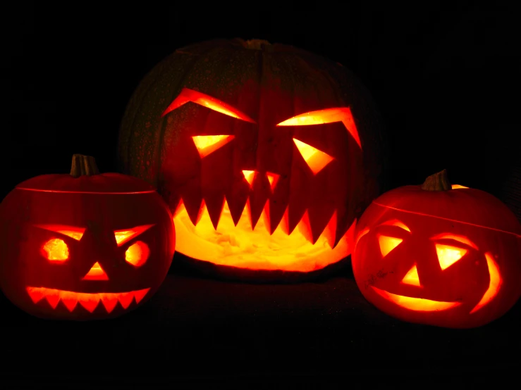 there are three carved pumpkins that appear to have faces on them