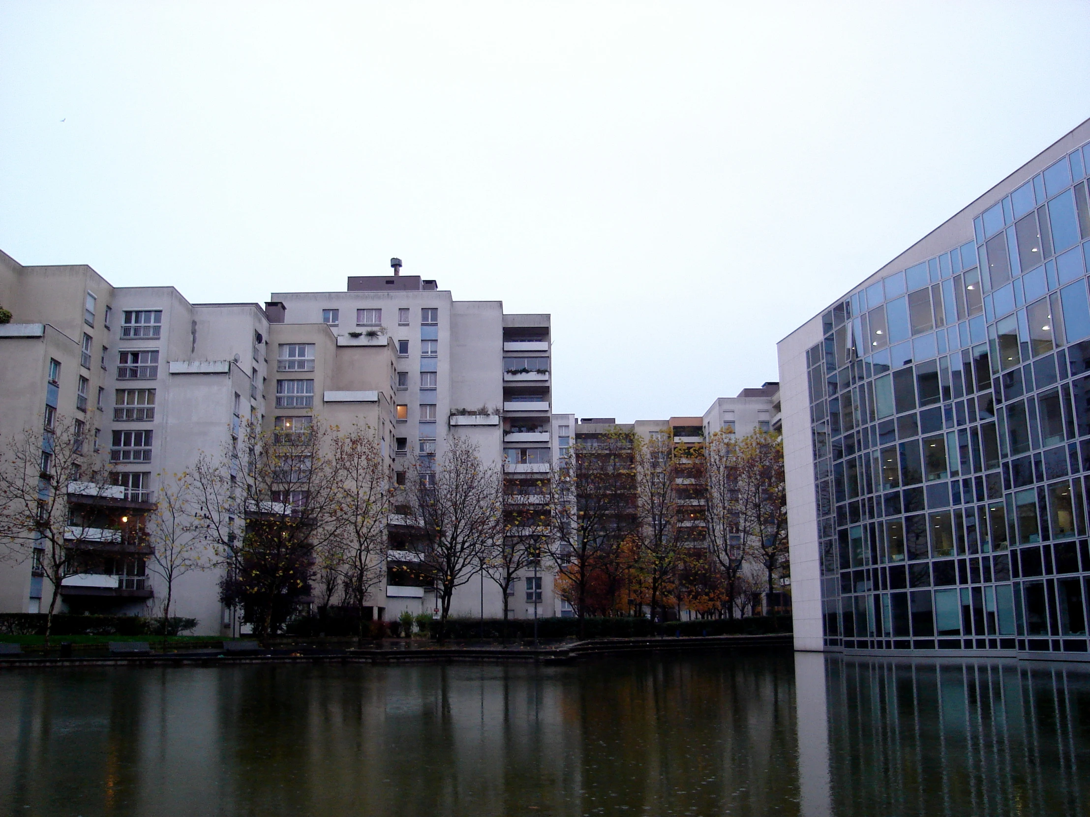 several buildings are in the background while a lake is in the foreground