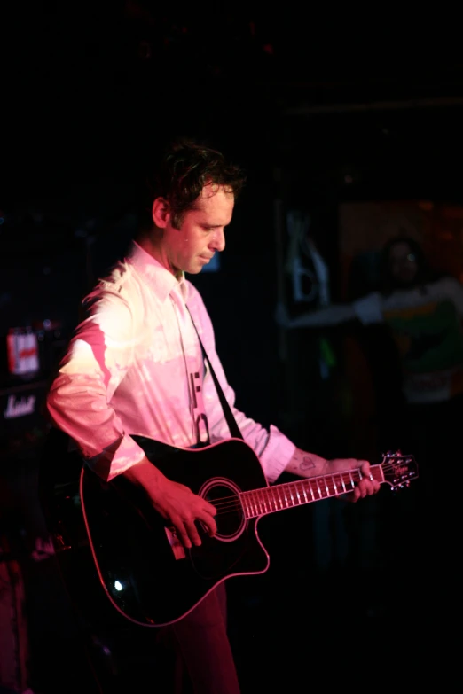 a man in a tie is playing the guitar