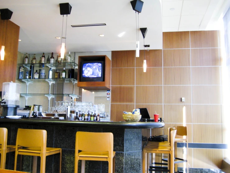 a bar in a restaurant with chairs around the bar