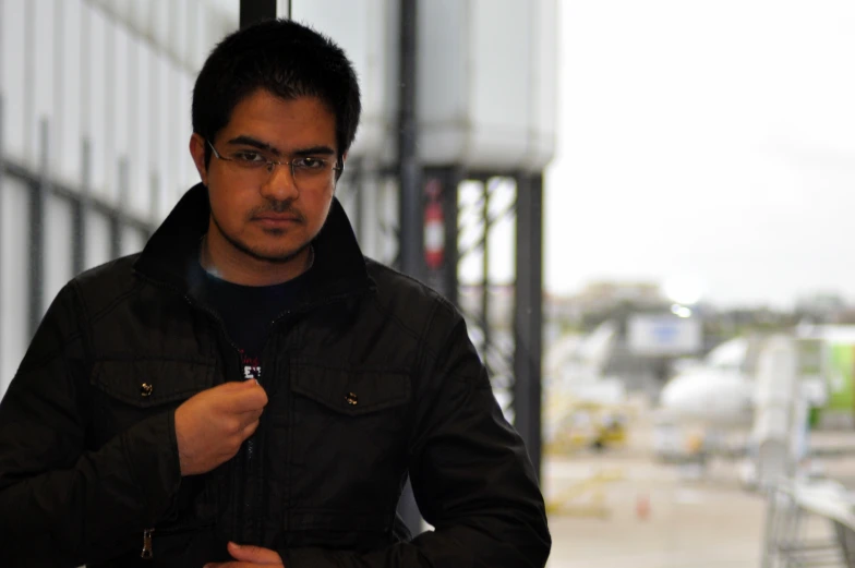 a man standing in front of an airport and holding onto his tie