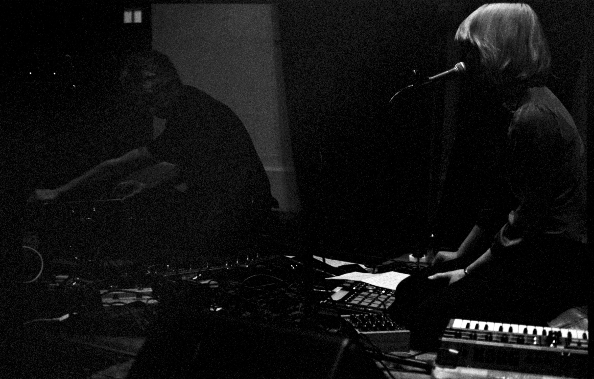 a woman is playing keyboard in front of microphones