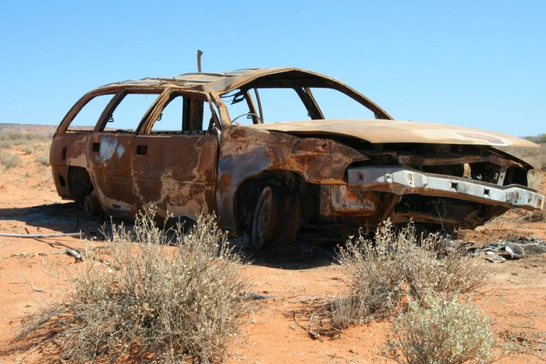 an old car is in the middle of nowhere