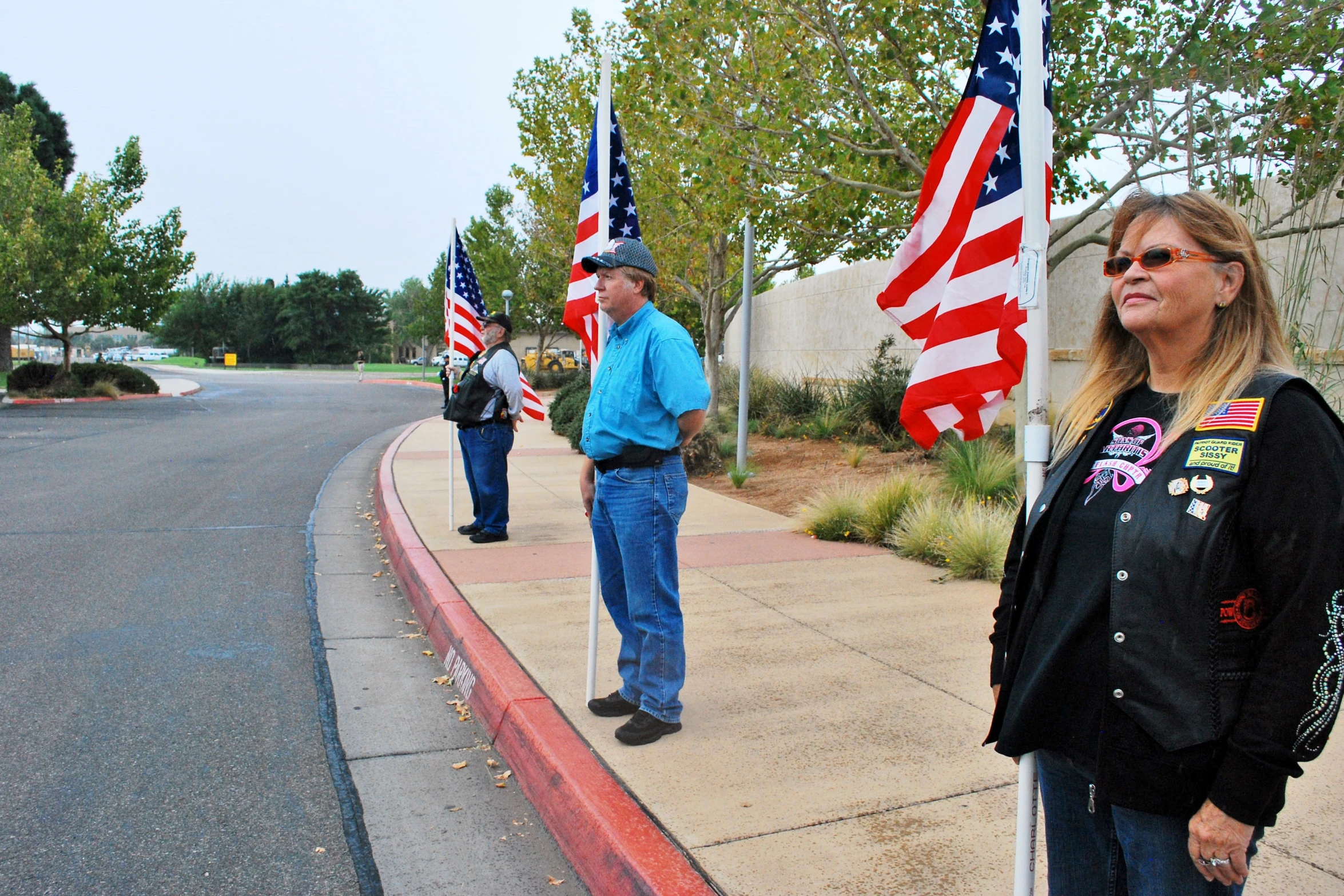 a woman and a man standing on a sidewalk with american flags