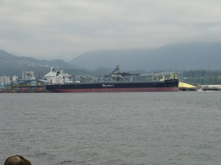 a large ship with two ships sitting on the water