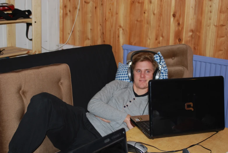 a person is laying on the couch using a laptop