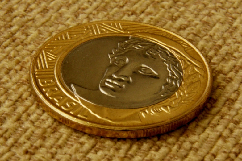 a close up view of a gold coin with a picture on the front