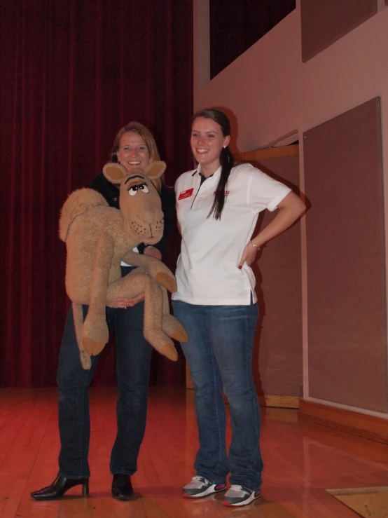 two people wearing glasses posing with a stuffed monkey