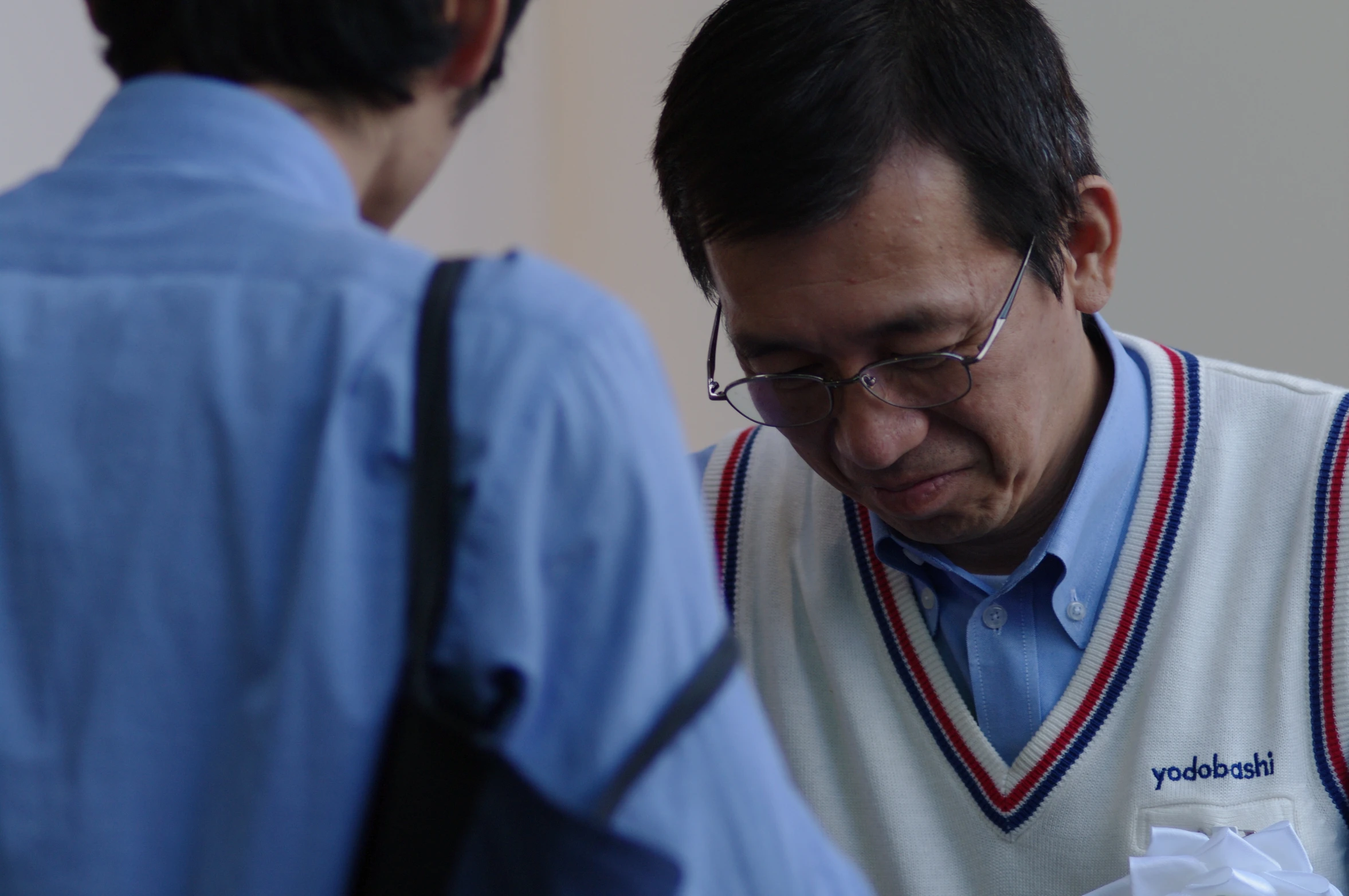 a man in a vest stands in front of a mans shoulder