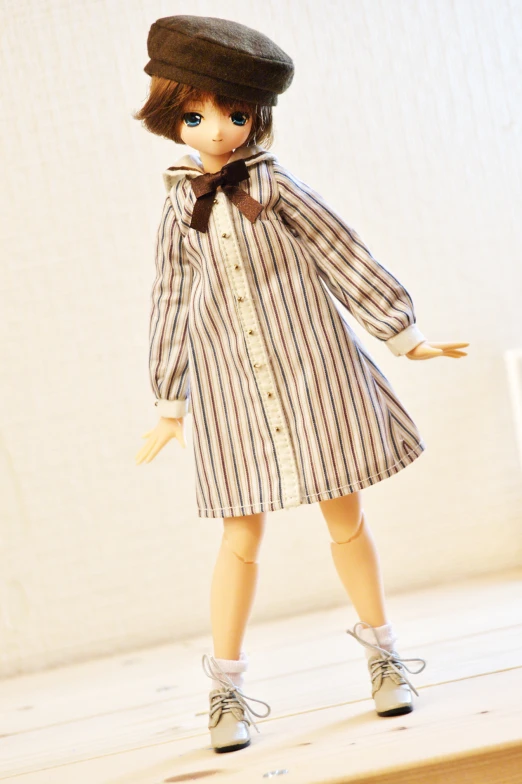 there is a doll wearing a hat and striped dress