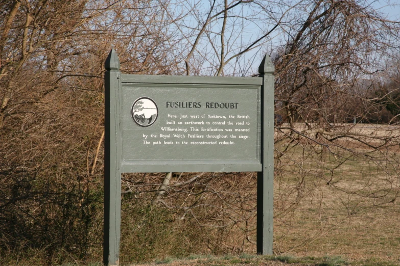 a sign with a picture in it next to trees