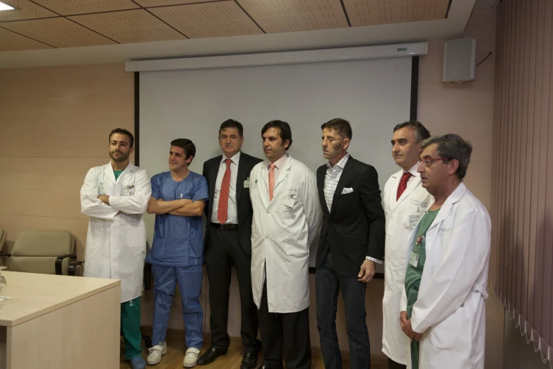 the doctors are standing by a table with their arms crossed