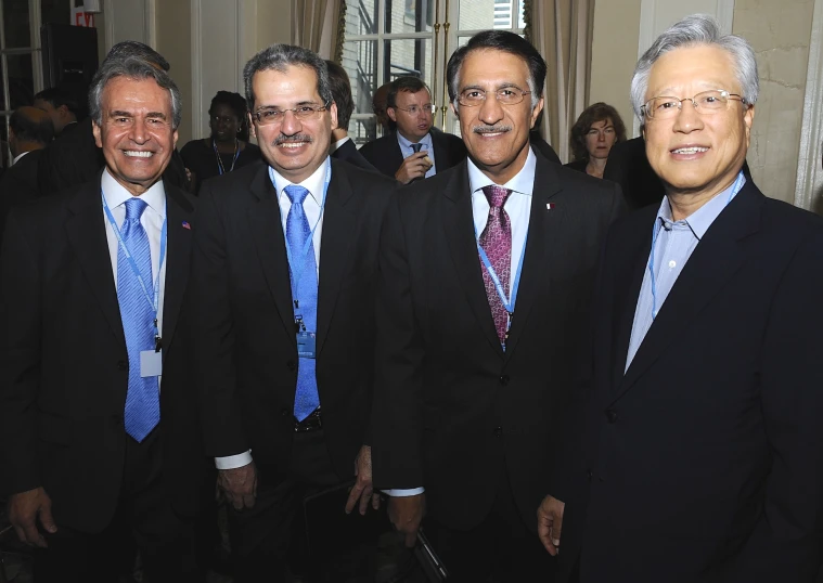 four men are all dressed up and standing together