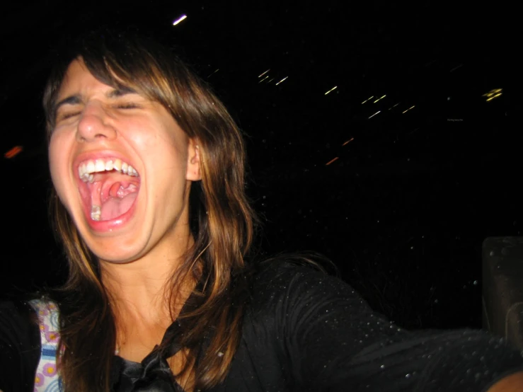 a young woman smiling and singing into her earpieces