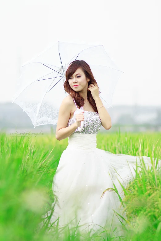 the woman in the wedding gown poses with an umbrella