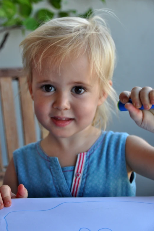 a little girl making a drawing with crayons