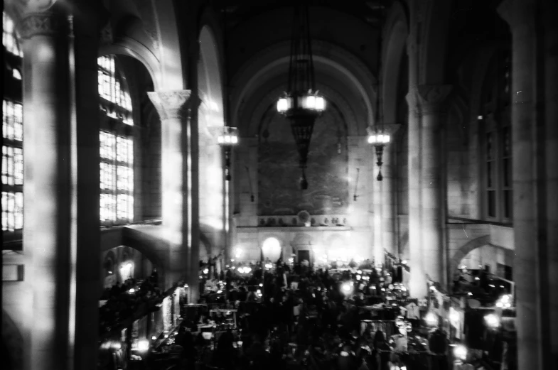 a view of a church in black and white with lights from tall windows