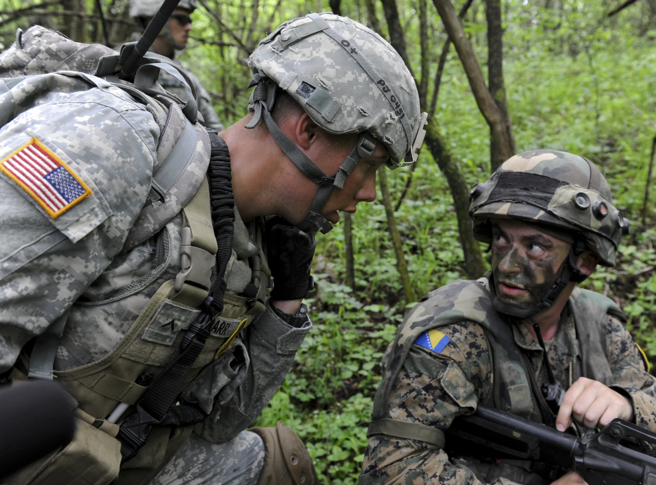 two military men in camouflage paint with guns