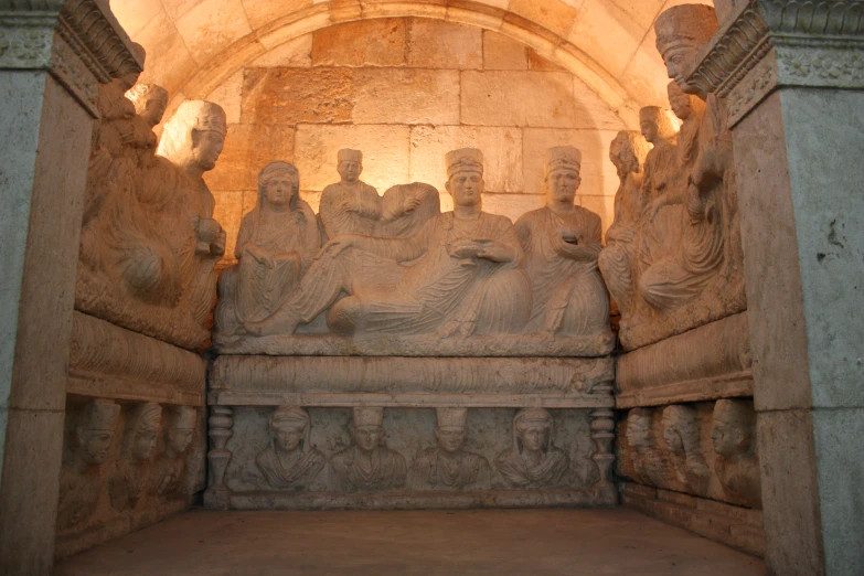 stone statues surround a monument in a museum