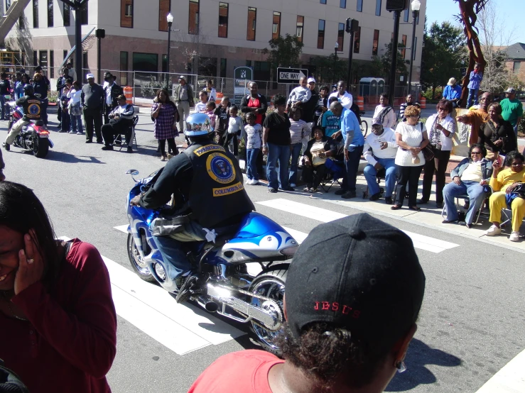 a police officer on a motorcycle parked in front of a crowd of people