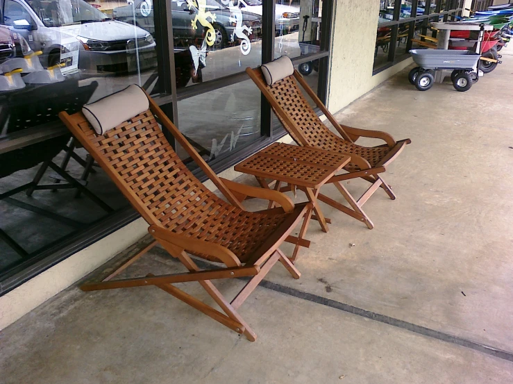 two chairs with a long tail are on the sidewalk next to the store