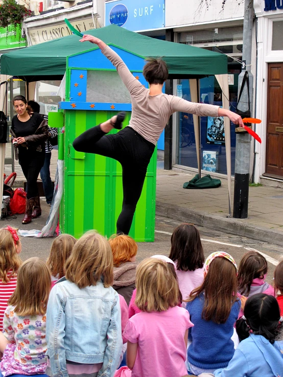 a person on a skateboard doing tricks as children look on