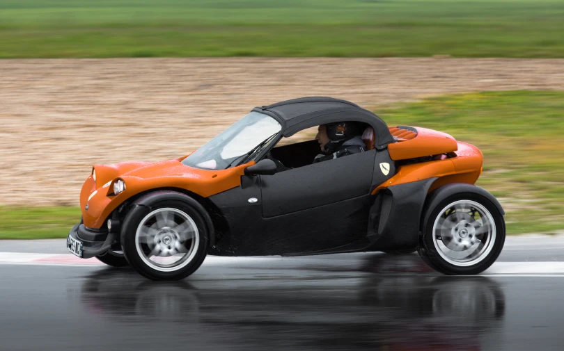 an orange and black sports car on a race track