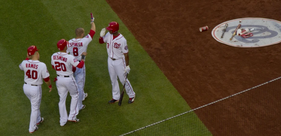 a baseball game in progress with the team and the base runner pointing his hand