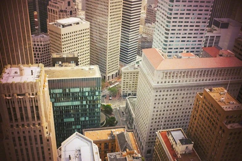 tall buildings on either side of a street are in the middle of a city