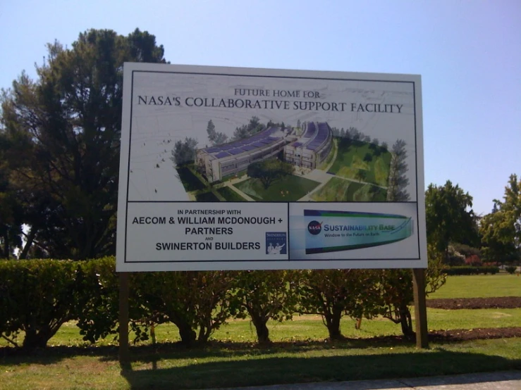 a large white sign is sitting in front of trees