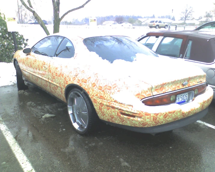 an orange car covered in a lot of snow