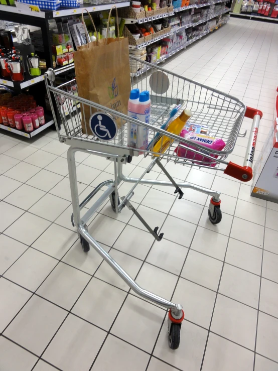 an empty shopping cart in a grocery store aisle