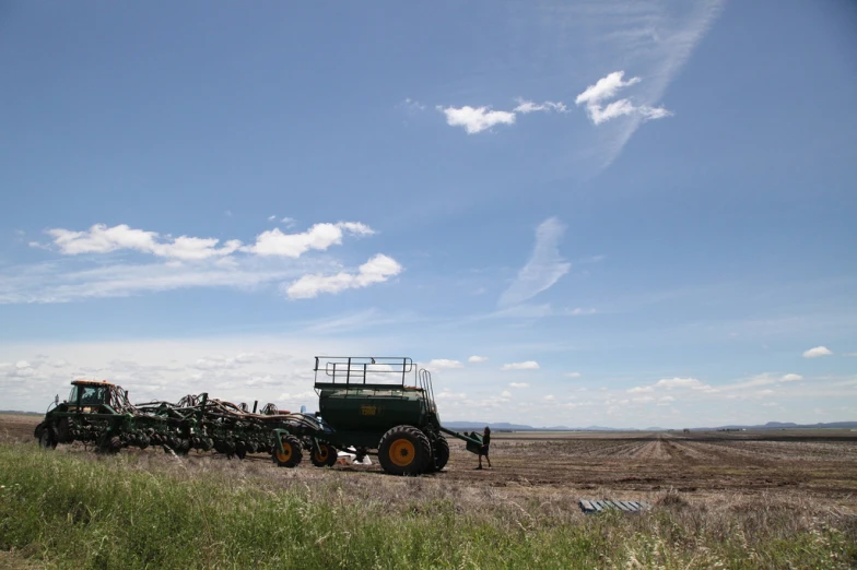 there is a truck and two tractors in the field