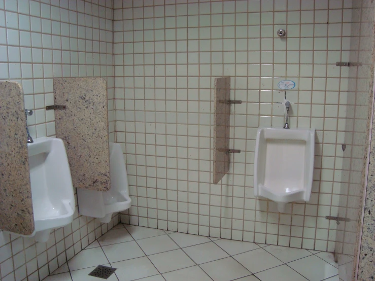 the urinals in a restroom are made of white porcelain