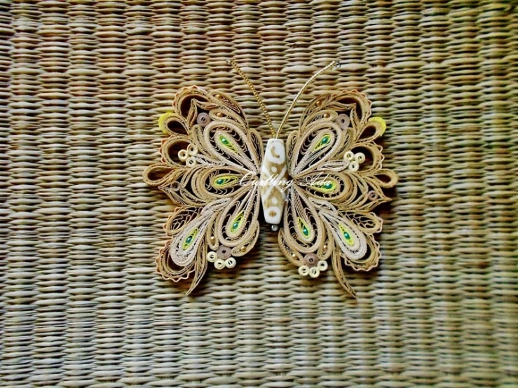 some kind of broach with green and white feathers