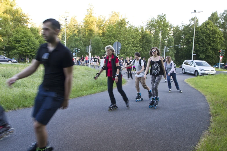 a group of people skateboarding down a small city street