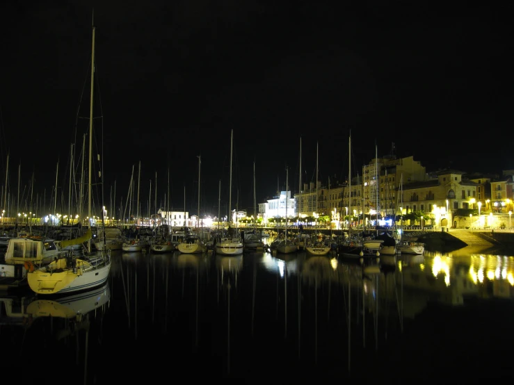 a dock with several boats docked at night