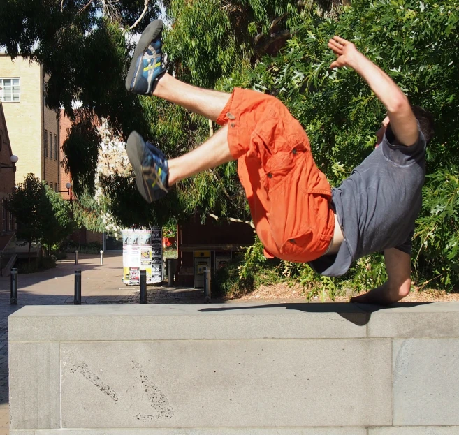 a skateboarder doing a trick on the edge of a wall