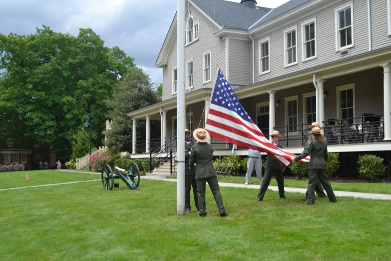 a group of uniformed soldiers holding a flag