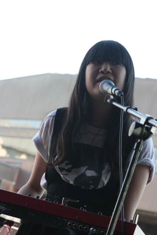 a woman standing next to a microphone at a microphone stand