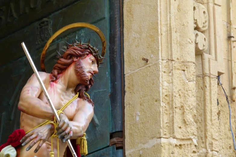 an outdoor statue of a male  in front of a building