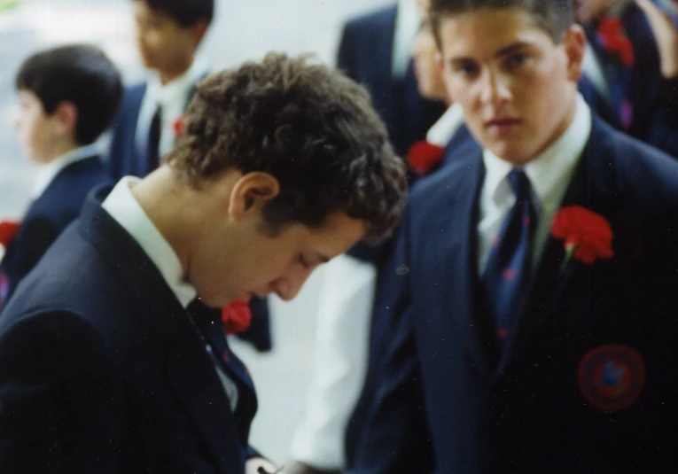 several men in suits with one holding a cell phone