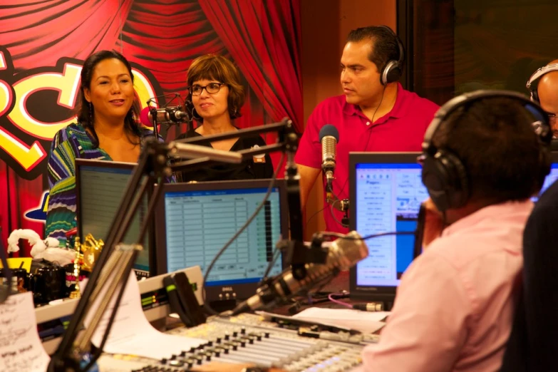 several people are gathered around a radio set